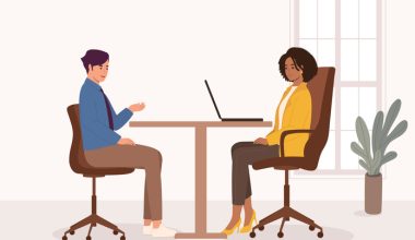 Side View Of Smiling Black Woman Manager Interviewing A Male Candidate At Office. Isolated On Color Background.