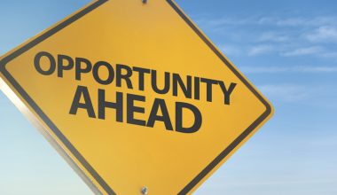 A yellow road sign against a blue sky that reads "Opportunity Ahead."