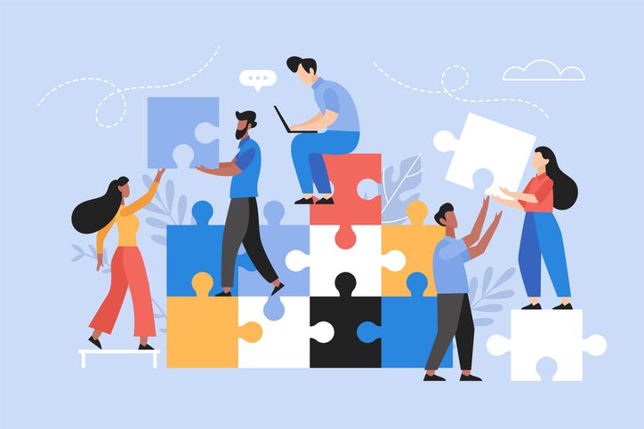 Illustration of people stacking large colorful puzzle pieces together.