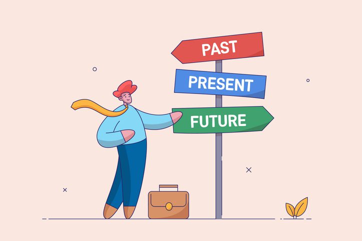 A cartoon businessman stands at a signpost with three arrows labeled "PAST," "PRESENT," and "FUTURE." He touches the "FUTURE" arrow, while a briefcase rests by his feet.