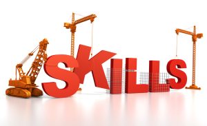 Illustration of the word “SKILLS” in large red 3D letters being constructed by three orange construction cranes and a bulldozer on a white background.
