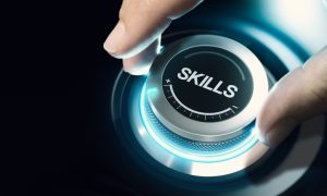 A hand adjusts a glowing, futuristic dial labeled “SKILLS,” symbolizing increasing or enhancing abilities.